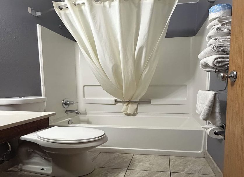 Coratel Inn and Suites by Jasper Stillwater bathroom with tub-shower combo and toilet