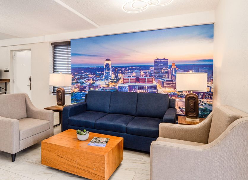 Clarion Pointe Winston - Salem Downtown lounge with cityscape mural, sofa, armchairs and coffee table in Winston-Salem