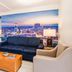 Clarion Pointe Winston - Salem Downtown lounge with cityscape mural, sofa, armchairs and coffee table in Winston-Salem