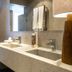 Frangipani Hotel Boutique bathroom in Brotas with double sink vanity, mirror and towel rack