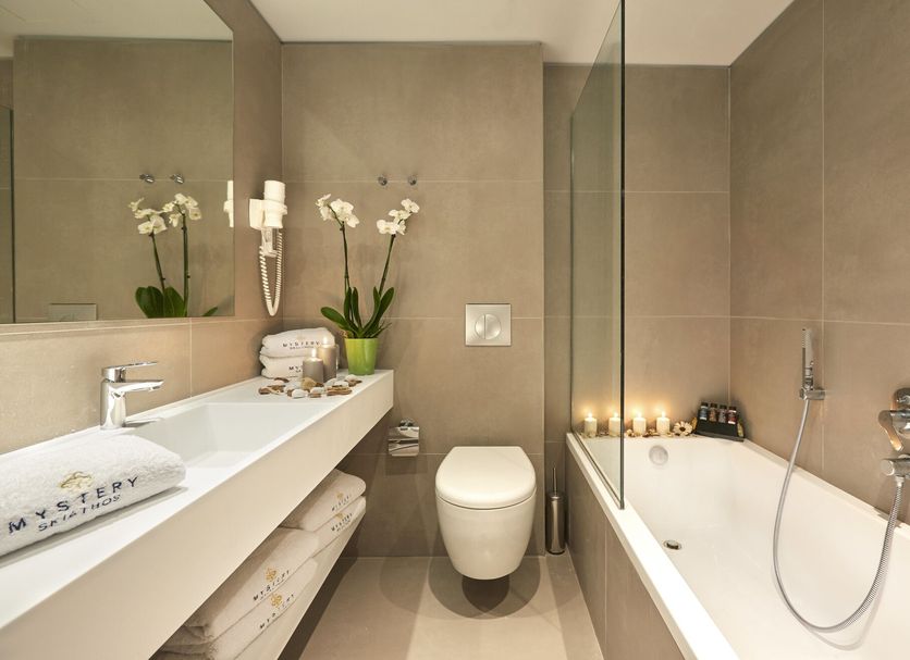 Mystery Skiathos Luxury Residence bathroom with bathtub, vanity, toilet and orchids in Skiathos