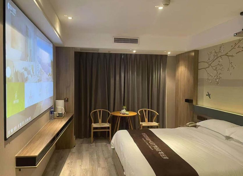 Anyi 158 Hotel Renming Park in Chengdu guest room with bed, projector screen and seating area