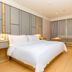 Ji Hotel Shenzhen Shennan Avenue Huaqiang guest room with a large bed, sofa, and floor-to-ceiling curtains in Shenzhen