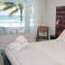 Bravo Beach Hotel, Vieques room with bed, ocean view, and balcony overlooking palm trees