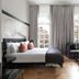 Holmes Hotel London guest room with king bed, lounge chairs and large street-facing windows in London