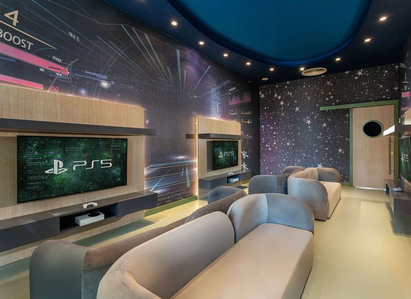 Titanic Deluxe Lara Antalya PS5 gaming room with loungers, wall screens and starry ceiling