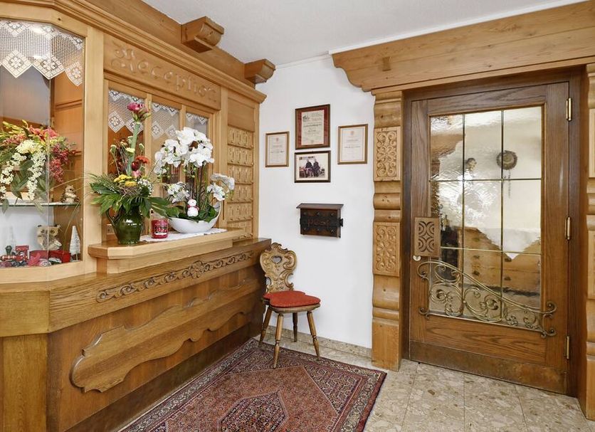 Hotel Montabella in Tschagguns lobby with carved wood reception desk and glass door