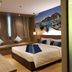 Bizotel Premier Hotel & Residence Bangkok guest room with king bed, sofa seating and harbor mural wall