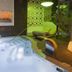 Hotel & Spa Princesa Munia in Oviedo: indoor spa pool with lounge chairs and green-lit relaxation area