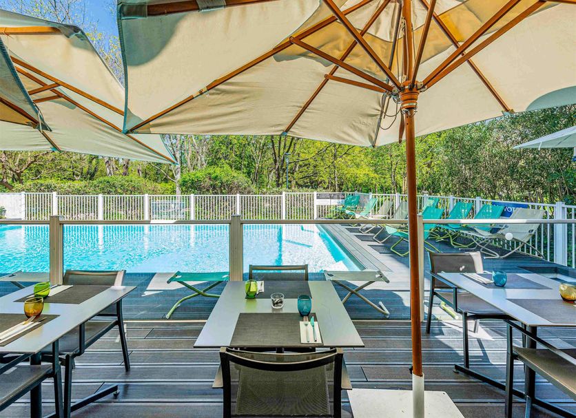Outdoor poolside terrace at Novotel Toulouse Centre Compans Caffarelli in Toulouse with umbrellas and lounge chairs