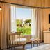 Villa Mansa room with a large window, seating area, wall-mounted TV, and garden view in Luján de Cuyo