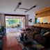 Casa Jardin Del Mango, San José: cozy lounge with sofa, TV, and sliding doors to a garden patio