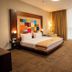 The Landmark Hotel in Baku guest room with king bed, colorful headboard art, and floor-to-ceiling windows