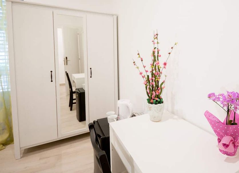 B&B Ponticello Palermo room with white wardrobe, desk, mirror and flowers