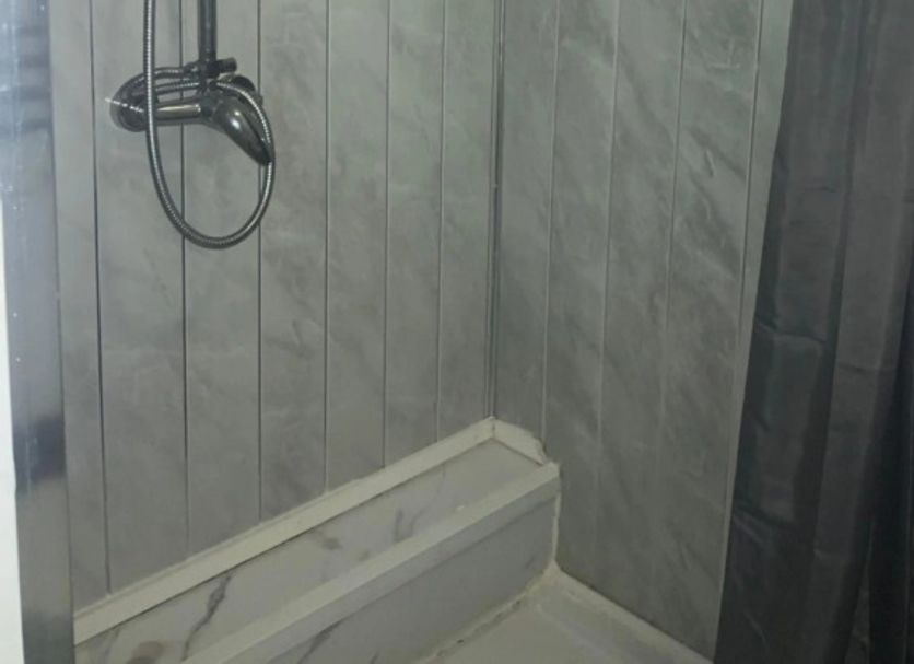 Self Contained Rooms in Central Torquay shower stall with grey tiled walls and handheld shower, Torquay