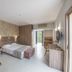 Electra Holiday Village Water Park Resort in Ayia Napa guest room with bed, sofa, desk and balcony doorway