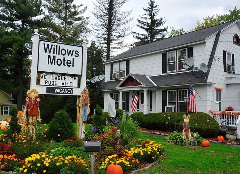 Willows Motel in Williamstown with landscaped garden, American flags, and two-story white building
