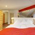Hotel Jakob in Groß-Umstadt bedroom with white bed, red blanket and large window drapes