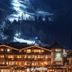Hotel Tipotsch in Stumm at night with illuminated balconies and a snowy mountainside backdrop