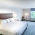Hampton Inn & Suites Berkshires-Lenox guest room with king bed, desk, chair and window in Lenox