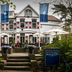 Fletcher Hotel Restaurant Boschoord in Oisterwijk with white facade, red shutters and garden terrace