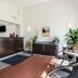 Motel 6 Newport News, VA reception area with front desk, chairs, potted plants and wall-mounted TV