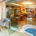 Hotel Santorini in Vila Velha: seaside lounge with striped seating and glass doors to a dining area
