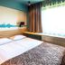 Ibis Styles Riga guest room with double bed, wall mural and large window in Riga