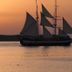 Sunset sailboat view over calm water at Theoxenia Caldera Hotel in Thera
