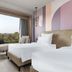 Mercure Chandigarh Tribune Chowk guest room with twin beds and a large window overlooking trees in Chandigarh