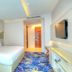 One One Bangkok Hotel guest room with king bed, wall-mounted TV, and colorful patterned carpet in Bangkok