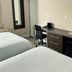 Hotel 21 NYC in Queens guest room with two beds, desk, chair and mini fridge