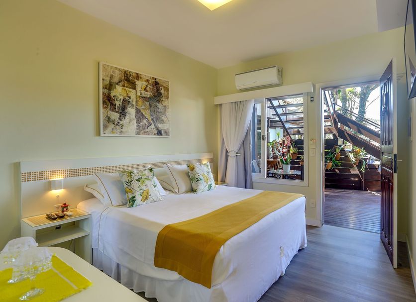 Nova Pousada Dos Chas in Florianopolis guest room with bed, balcony door, and garden view
