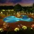 Clarks Khajuraho pool lit at night with landscaped gardens and lounge chairs in Khajurāho
