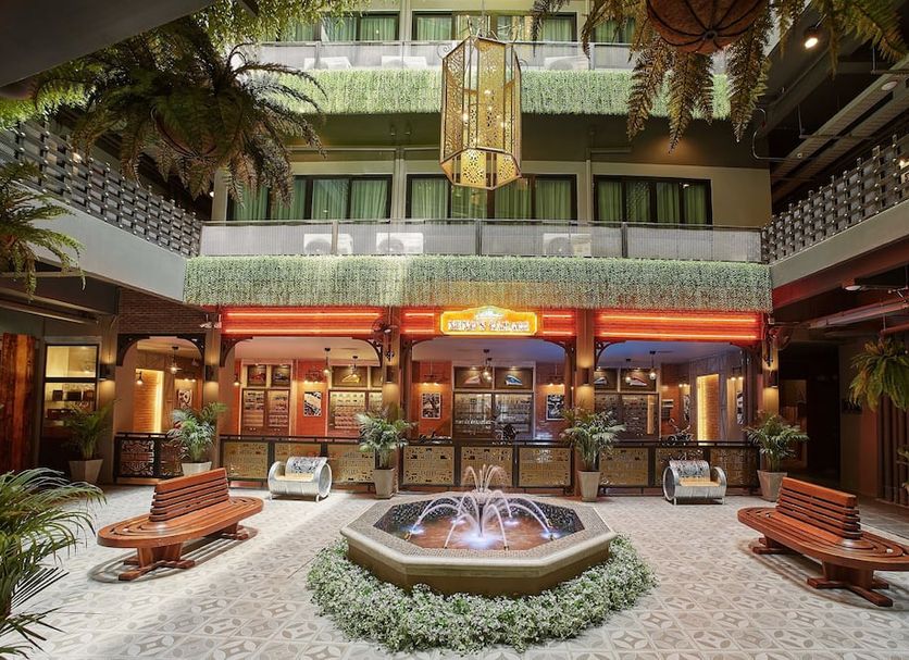 W22 Hotel by Burasari Bangkok atrium courtyard with central fountain, benches and hanging lanterns