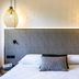 ibis Styles Rennes Cesson bedroom with double bed, gray upholstered headboard and woven pendant lamps in Cesson-Sévigné