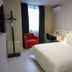 Jinjiang Inn - Nanning International Exhibition Center guest room with bed, desk, and red armchair in Nanning