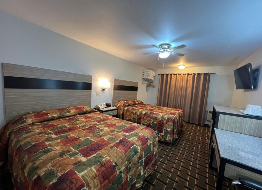 Deluxe Inn Capital O Nebraska City I 29 room with two beds, TV, and curtain-covered window
