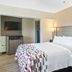 Red Roof Inn & Suites Fayetteville-Fort Bragg room with queen bed, wall-mounted TV, and bedside lighting