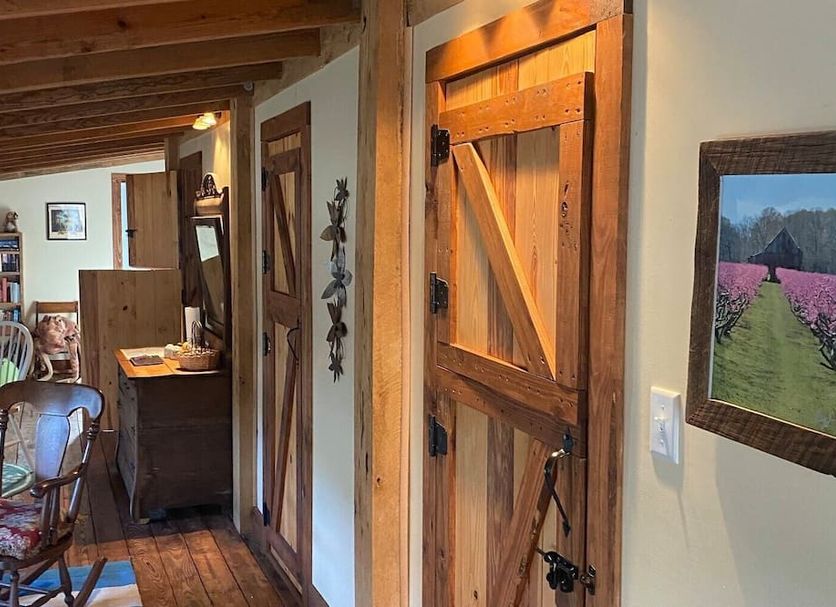 The Bed and Breakfast at Peace Hill Farm in Charles City: rustic hallway with barn-style wood door