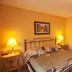 Ard na Breatha in Donegal bedroom with wrought-iron bed, bedside lamps and wooden door