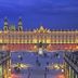 Hotel Les Portes D'Or in Nancy overlooking a lit historic square at dusk
