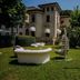 Hotel De la Ville in Riccione with a garden lounge, white seating, and a sculptural chair