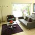 Hb Córdoba lounge in Córdoba with gray sofas, purple rugs, and bright windows