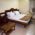 Hotel Sunil Krishna in Tirupati guest room with double bed, chair, table, and curtained window