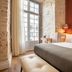 Boemio Flh Hotels Lisbon guest room with king bed, tufted bench, and tall windows
