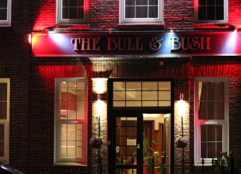The Bull And Bush Hotel Kingston entrance at night, red-lit brick facade in Kingston upon Thames