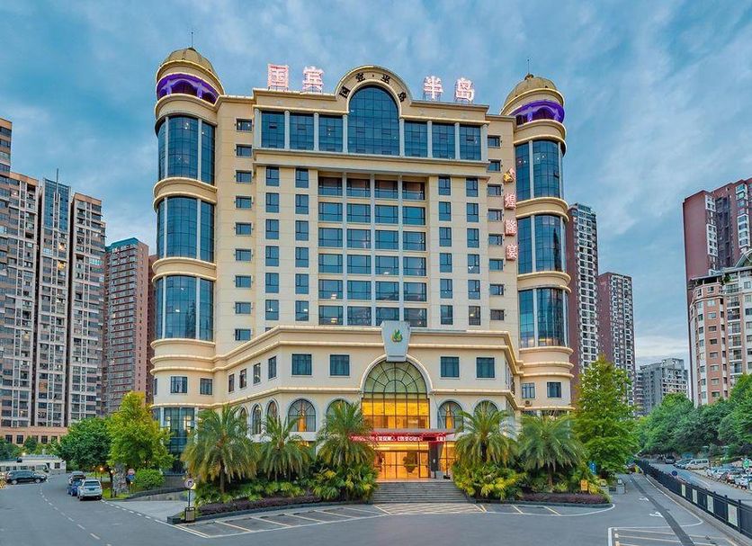 Yichang Guobin Bandao Hotel in Yichang, 4-star hotel exterior with palm-lined entrance and towers
