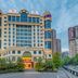 Yichang Guobin Bandao Hotel in Yichang, 4-star hotel exterior with palm-lined entrance and towers