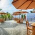 Arugambay Roccos in Arugam, outdoor terrace with tables, umbrellas, palm trees and sea view